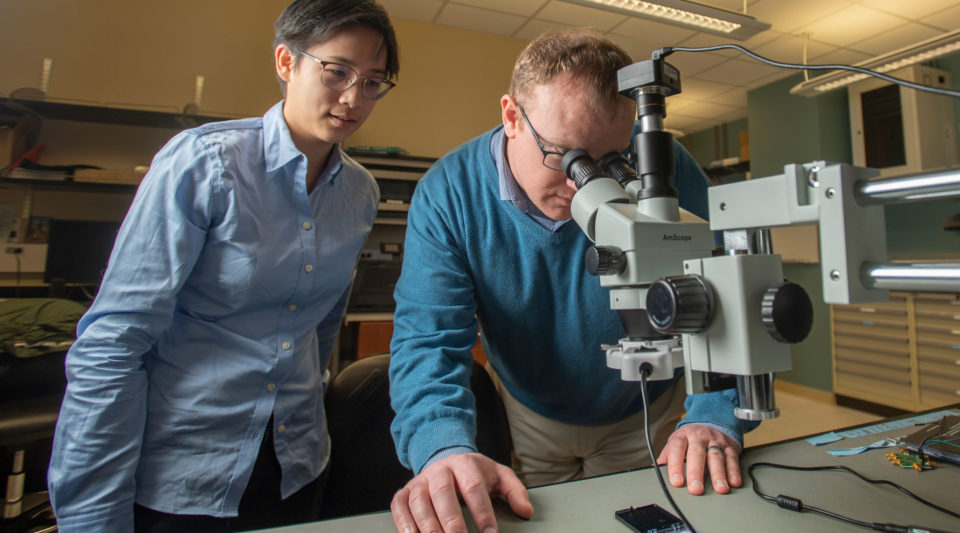 Thomas O’Sullivan and Alicia Wei using a microscope